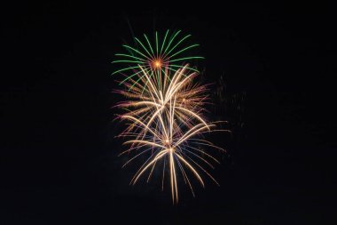 Karanlık gökyüzü arkaplanlı havai fişekler. Yeşil, sarı, turuncu, mavi ve kırmızı. Bağımsızlık Günü Kutlaması, Santa Clarita, California. 