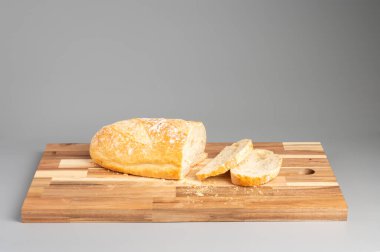 Tahta kesme tahtasının üzerinde dilimlenmiş taze pişmiş ekmek. Tarifler, bloglar ve mutfak tasarımı için uygun Rustik ahşap kesim tahtası arka planı.