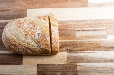 Tahta bir kesme tahtasının üzerinde dilimlenmiş zanaatkar ekmeği. Tarifler, bloglar veya tasarım tasarımları için bir genel düz olarak tasarlanmış, temiz kopya alanı ile yukarıdan aşağı bir perspektiften yakalanmış.