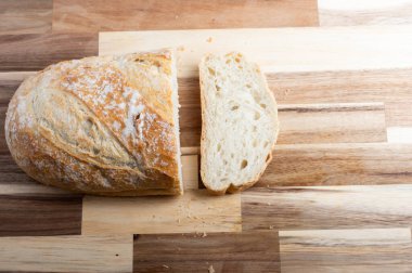 Tahtaya bir dilim kesilmiş bir somun rustik ekmek. Tarifler, bloglar veya tasarım tasarımları için bir genel düz olarak tasarlanmış, temiz kopya alanı ile yukarıdan aşağı bir perspektiften yakalanmış.