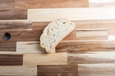 Tahta kesme tahtasının üzerinde bir dilim ekmek. Tarifler, bloglar veya tasarım tasarımları için bir genel düz olarak tasarlanmış, temiz kopya alanı ile yukarıdan aşağı bir perspektiften yakalanmış.