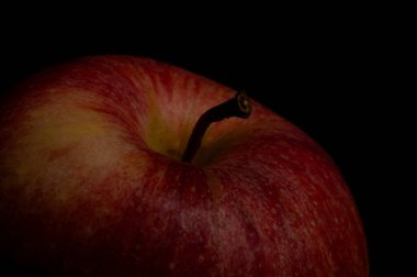 Koyu arkaplanı olan kırmızı bir elmanın yakın çekimi.