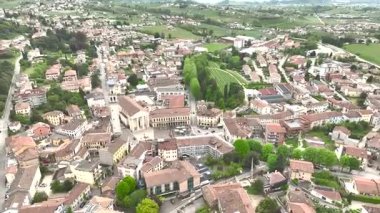 İlkbaharda Kulesi ve Tarihi Binaları olan bir Ortaçağ İtalyan Köy Merkezi 'nin Hava Aracı Görüntüsü. İtalyan kırsalındaki resim gibi bir ortaçağ köyünün uzun çan kulesiyle merkez meydanına odaklanan hava aracı görüntüleri..
