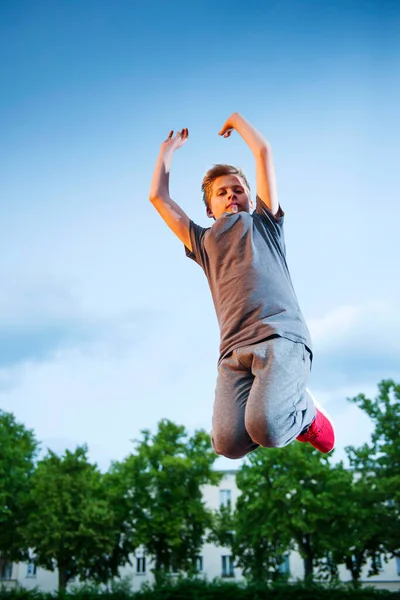 Pełny Widok Ciało Nastolatka Skaczącego Powietrzu Ramionami Wyciągniętymi Boisku Sportowym — Zdjęcie stockowe