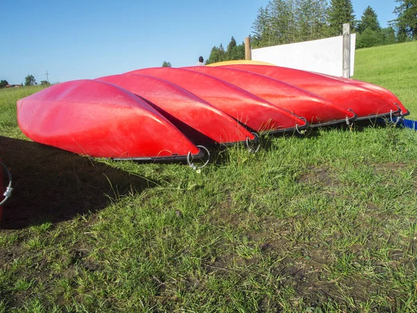 バイエルン州の丘陵地帯の牧草地に逆さまの列に赤いカヌー — ストック写真