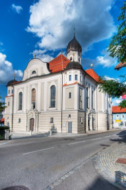 Nesselwang, Almanya - 06 Temmuz 2023: Nesselwang 'daki Saint Andreas Kilisesi' nin geniş açılı köşesi beyaz bulutlu mavi gökyüzüne karşı.