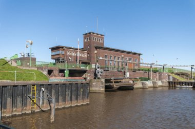 Harlesiel, Germany - April 02, 2023: Perspective view of the lock, the sluice inlet and the pumping station inlet at the inner harbor basin. clipart