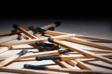 Geri çekilen bir arkaplanda yanmış kibritlerin düşük açılı yakın plan görüntüsü.