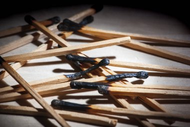 Geri çekilen bir arkaplanda yanmış kibritlerin düşük açılı yakın plan görüntüsü.