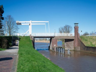Harle 'deki eski Sielschleuse manzarası, bugünün Friedrichsschleuse' si, 1765 yılında Harlesiel ve Carolinensiel arasında inşa edilmiş, Doğu Frizya, Aşağı Saksonya 'da mavi gökyüzüne karşı bir basküle köprüsü ile.