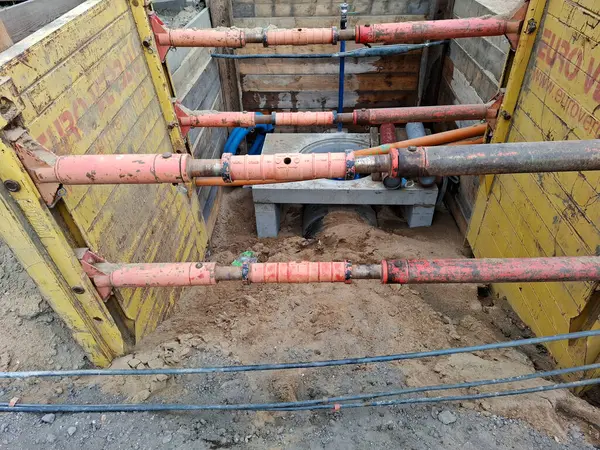 Berlin, Almanya - 16 Mayıs 2025: Landsberger Allee 'de bir akış ölçüm noktası inşa etmek için su kaynaklarının desteklenen bir inşaat siperine bakın.