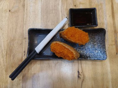 Pirinçle doldurulmuş kızarmış tofu ve balık yumurtası, wakame, yumurta gibi çeşitli malzemeler.