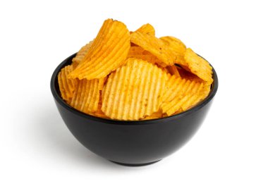Beyaz arka planda izole edilmiş siyah kasede sarı patates cipsi.