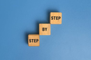 Adım adım ahşap bloklardaki merdivenlerde mavi arka planda izole edilmiş. Başarı ya da kariyer kavramı