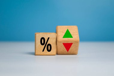 Beyaz ve mavi arka planda izole edilmiş tahta üzerinde yukarı ve aşağı ok olan yüzdelik sembolü. Faiz oranı kavramı finansal ve ipotek oranı büyümesi