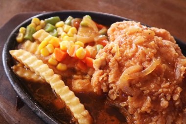 Sos, patates, mısır, havuç, fasulye ve soğanlı cızırtılı kızarmış tavuk tabağı. Lezzetli konfor yemeğini ve sağlıklı yemeği simgeliyor..