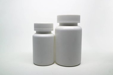 Two plain white plastic pill bottles with ribbed caps standing side-by-side on a clean white background, representing medicine, health, supplements, and containers.