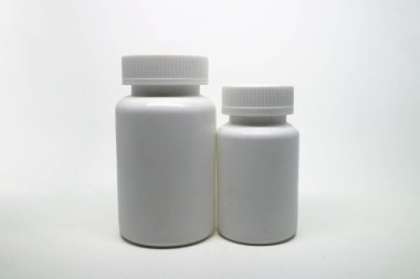 Two plain white plastic pill bottles with ribbed caps standing side-by-side on a clean white background, representing medicine, health, supplements, and containers.