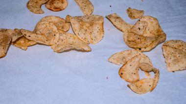 Lezzetli ve lezzetli. Kıtır kıtır patates cipsleri beyaz ya da açık renkli bir yüzeye gevşek bir şekilde yayılmış..