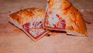 Lezzetli ve baştan çıkarıcı ev yapımı iki dilim ekmeğin detaylı makro görüntüsü beyaz rendelenmiş peynir dolgusu ve ekmeğin üzerindeki kırmızı et tabakasını vurguluyor..