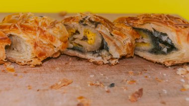 Lezzetli ve lezzetli bir Endonezya yemeği, muz boleni, rendelenmiş peynirle kaplanmış, ahşap bir tahtanın üzerinde..