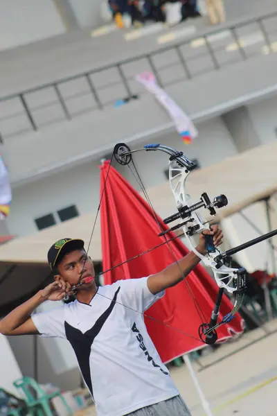 Banda Aceh, Endonezya - 3 Ekim 2025: Bir açık hava okçuluğu sırasında modern bir bileşik yay ile odaklanmış genç okçu