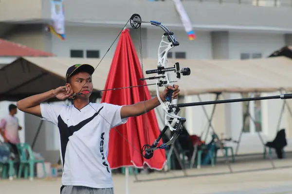 Banda Aceh, Endonezya - 3 Ekim 2025: Bir açık hava okçuluğu sırasında modern bir bileşik yay ile odaklanmış genç okçu