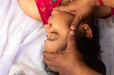 Osteopat doktor boyun bölgesiyle ve hastanın başıyla çalışıyor. Yakından bak, masör.