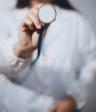 Elinde steteskop tutan genç bir erkek doktor.