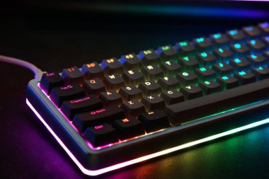 Keyboard features vibrant RGB lighting that enhances the workspace atmosphere. Perfect for gamers and enthusiasts, it showcases a sleek design and responsive keys.