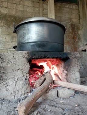 Geleneksel ateş çukurunun içinde yanan bir ateş ve tepesinde büyük bir buharlı