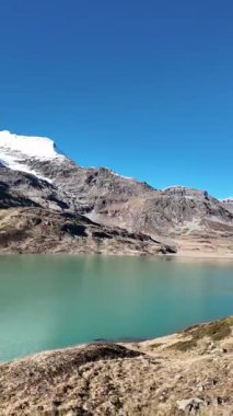 İsviçre 'nin İsviçre Alpleri' ndeki Bernina Geçidi üzerindeki Lago Bianco 'nun (Beyaz Göl) havadan görünüşü. Dağlarla, buzullarla ve ünlü Bernina demiryollarıyla çevrili manzaralı bir dağ deposu. Seyahat, turizm, doğa, manzara ve macera kavramları için mükemmel..