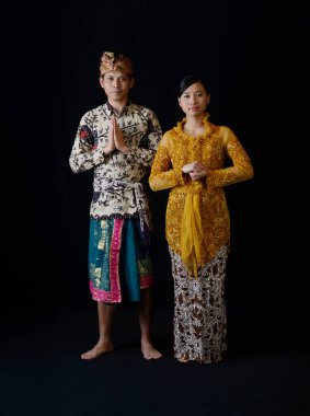 Endonezyalı bir erkek ve kadın geleneksel giyinmiş, birlikte duruyor ve Endonezya kültür mirasını ön plana çıkarıyor.