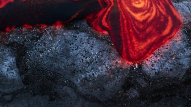 Erimiş lav katı lav kayaları üzerinde akıyor volkanik aktiviteler ve jeolojik süreçler sergiliyor.