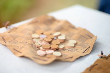 Tarihi tasarım ve işçiliğin ön plana çıkarıldığı, detaylı şekillendirilmiş deri bir tahtanın yuvarlak parçalarıyla antik bir Roma oyununun kopyası.