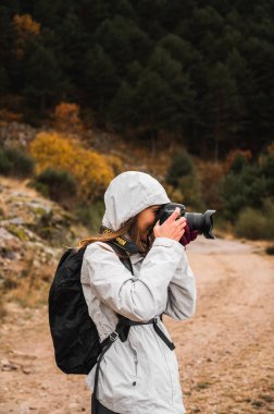 Sonbahar ormanlarında yağmurlu kız fotoğrafçı.