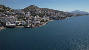 Sarandas 'ın turkuvaz suları, tepeleri ve plajlarıyla muhteşem bir kıyı manzarası. Seyahat, turizm ve Akdeniz manzarası için mükemmel..