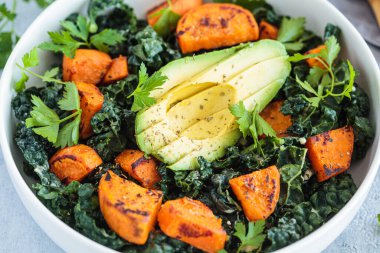 Kızarmış patates, avokado, beyaz kasede lahana salatası, yakın plan. Alternatif, sağlıklı, bitki temelli tarif.