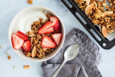 Ev yapımı yeşil karabuğday ve hindistan cevizli yoğurt ve beyaz kasede çilek, üst manzara. Sağlıklı bitkisel gıda konsepti.