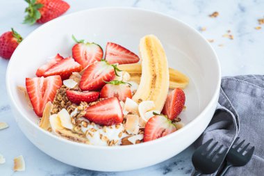 Yunan yoğurdu, çilek, ev yapımı tahıl gevreği ve organik fıstık ezmesi içeren sağlıklı vegan muzlu börek tarifi..