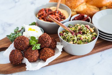 Geleneksel Şabat masası: Challah ekmeği, falafel, kinoa salatası, tahtadan yapılmış humus. İsrail gıda konsepti.