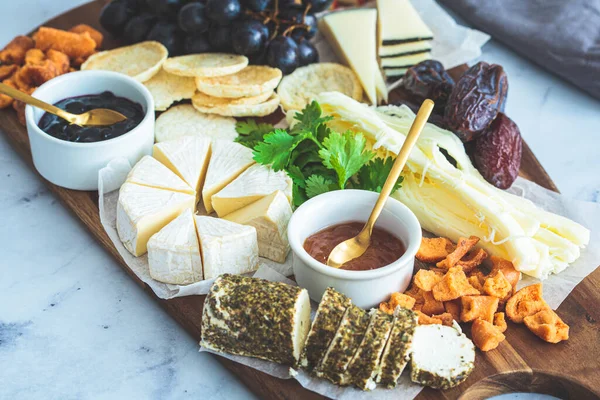 stock image Cheese board with fruits and crackers, close-up. Party food, food platter, european appetizers.