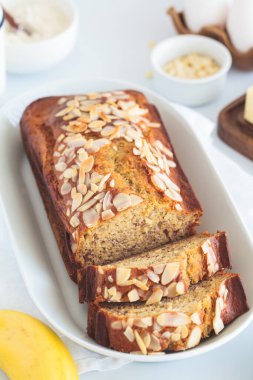 Beyaz zemin üzerinde badem olan muzlu ekmek..