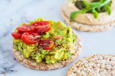 Avokado ve domatesli sağlıklı kızarmış ekmek, yakın plan. Vegan kahvaltı konsepti.