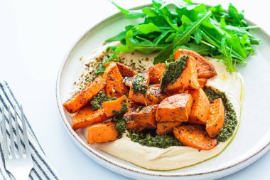 Vejetaryen yemeği - humus, fırında tatlı patates ve pesto, beyaz arka plan, yakın plan.