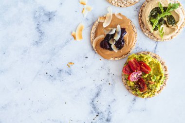 Avokado, fıstık ezmesi ve humus soslu sağlıklı kızarmış ekmek. Vegan kahvaltı konsepti.