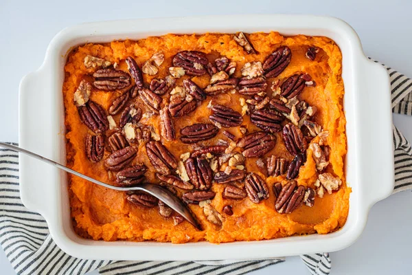 Geleneksel tatlı patates güveci, cevizli, üst manzaralı, beyaz arka planlı. Tatil tarifi.