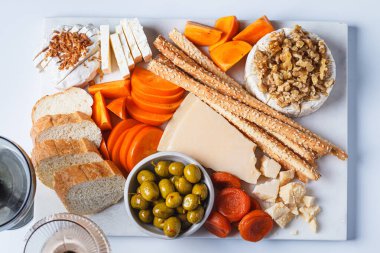 Parti için beyaz mermer bir tahtada hurma, zeytin ve şarap tabağı..