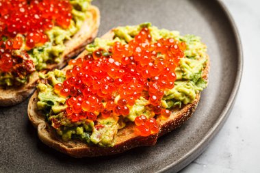 Kırmızı havyar ve avokado guacamole tostlu çavdar ekmeği, yakın plan., .