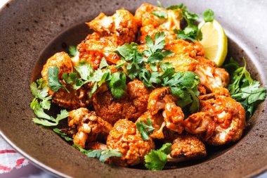 Domates soslu fırında karnabahar, otlar, beyaz arka plan, yakın plan. Vegan tarifi.